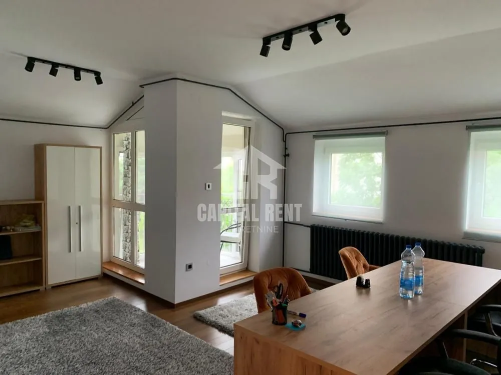 Spacious bright room with a desk and shelving units.