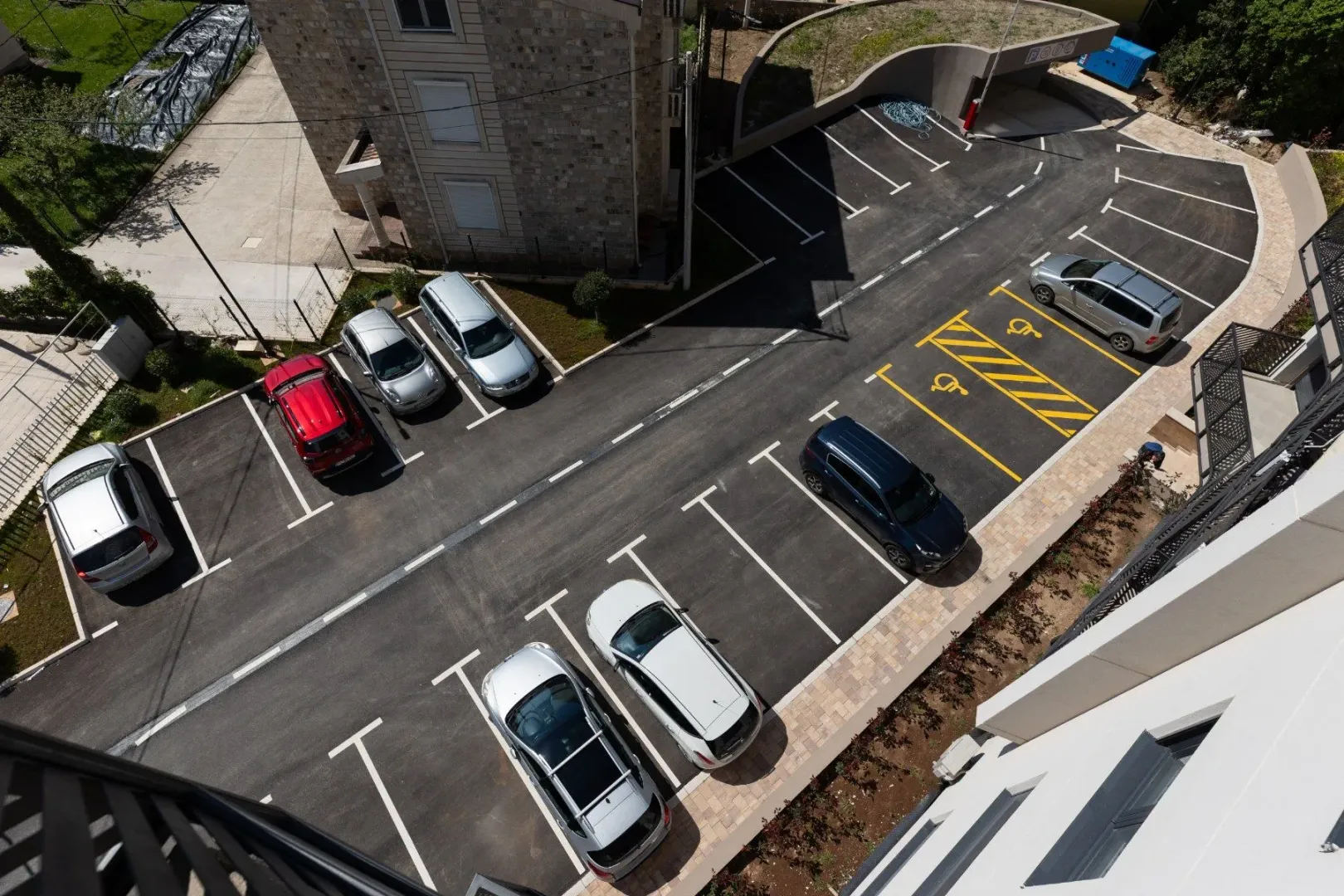 Pogled odozgo na parking prostor i dio stambene zgrade.
