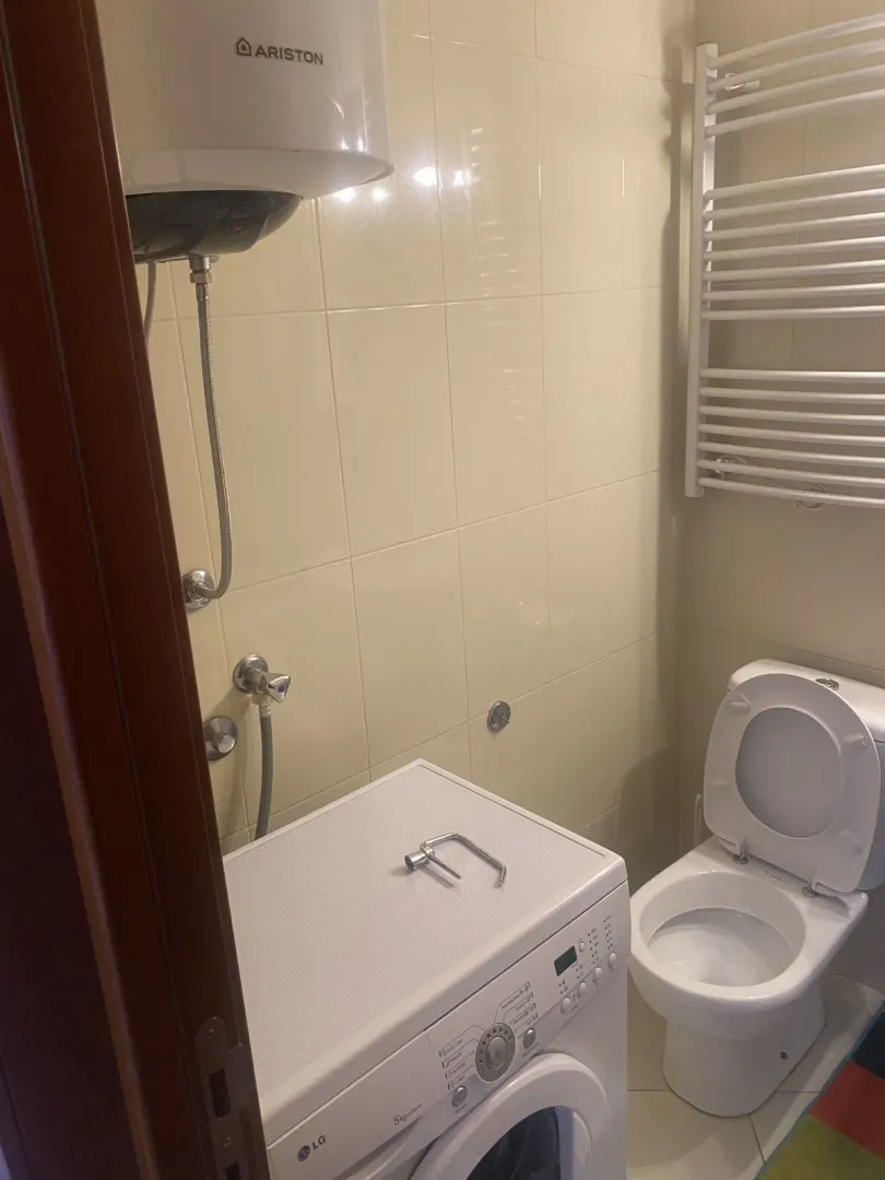 Bathroom featuring a washing machine, water heater, and toilet.
