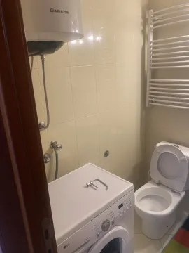 Bathroom featuring a washing machine, water heater, and toilet. - image 14