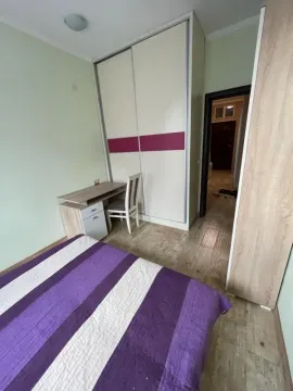 Furnished bedroom with a bed, wardrobe and a desk. - image 8