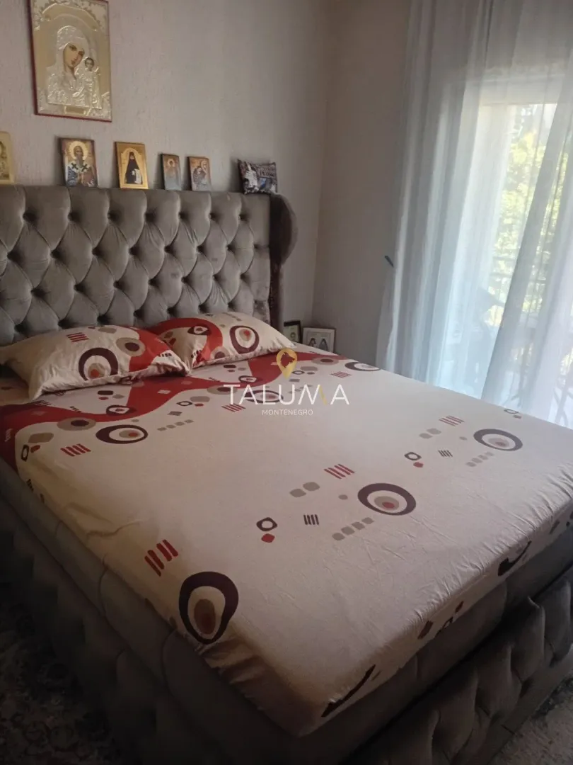 Bedroom with a large double bed with a tufted headboard.