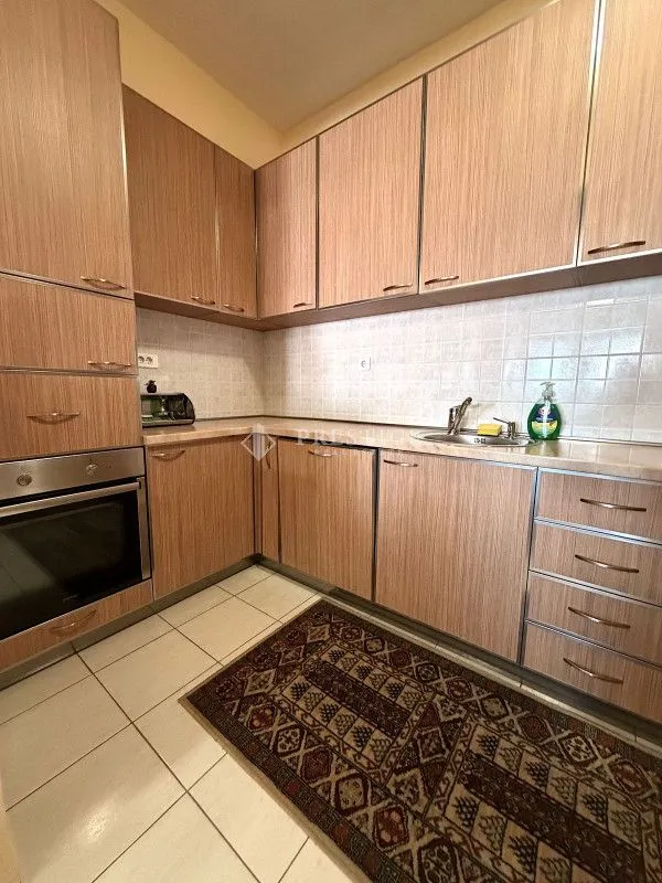 Kitchen with wooden cabinetry and built-in oven.