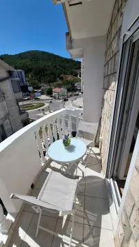 Furnished balcony with a table, chairs, and surrounding views. - image 10