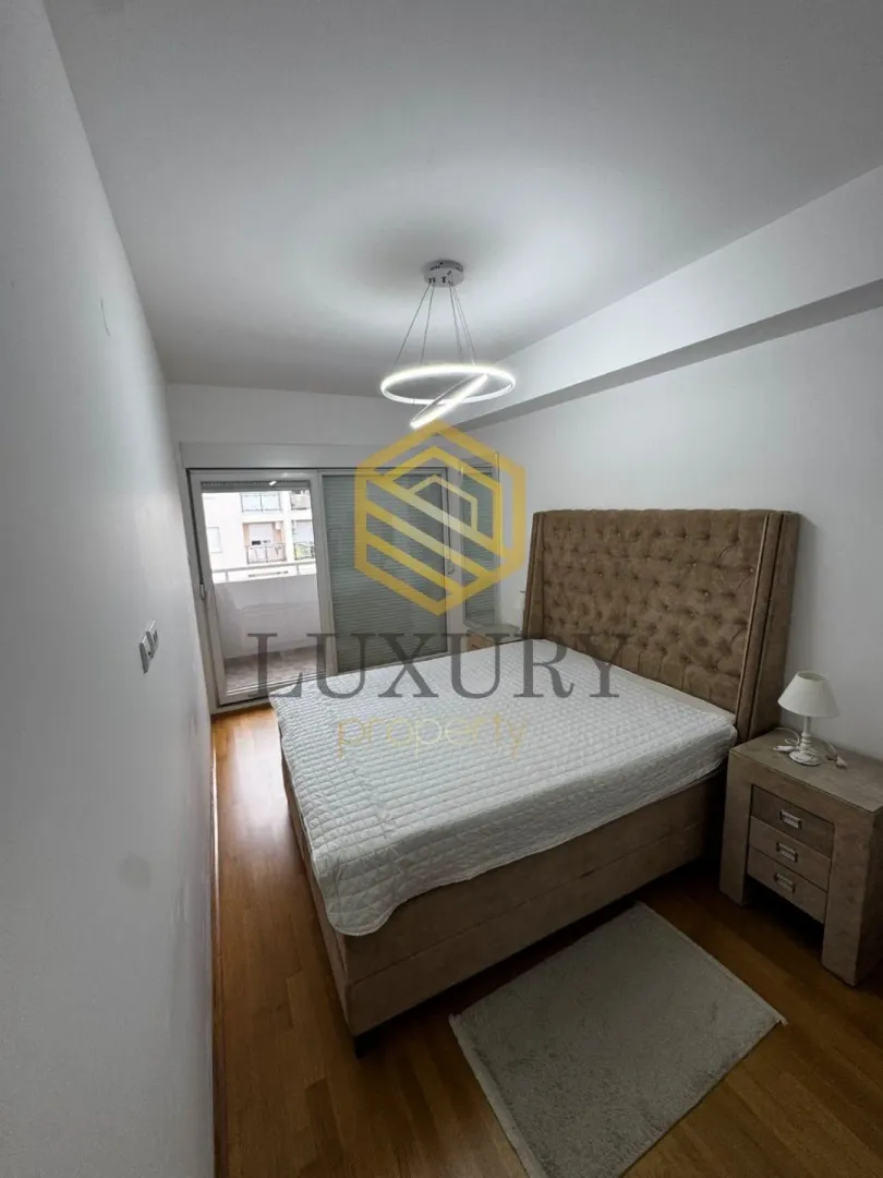 Furnished bedroom with a double bed and balcony access.