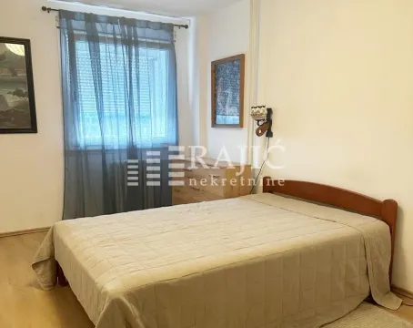 Bedroom with a double bed, window with curtains, and wooden furniture. - image 10