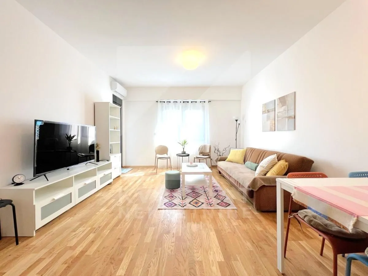 Living room with sofa, television and dining table.