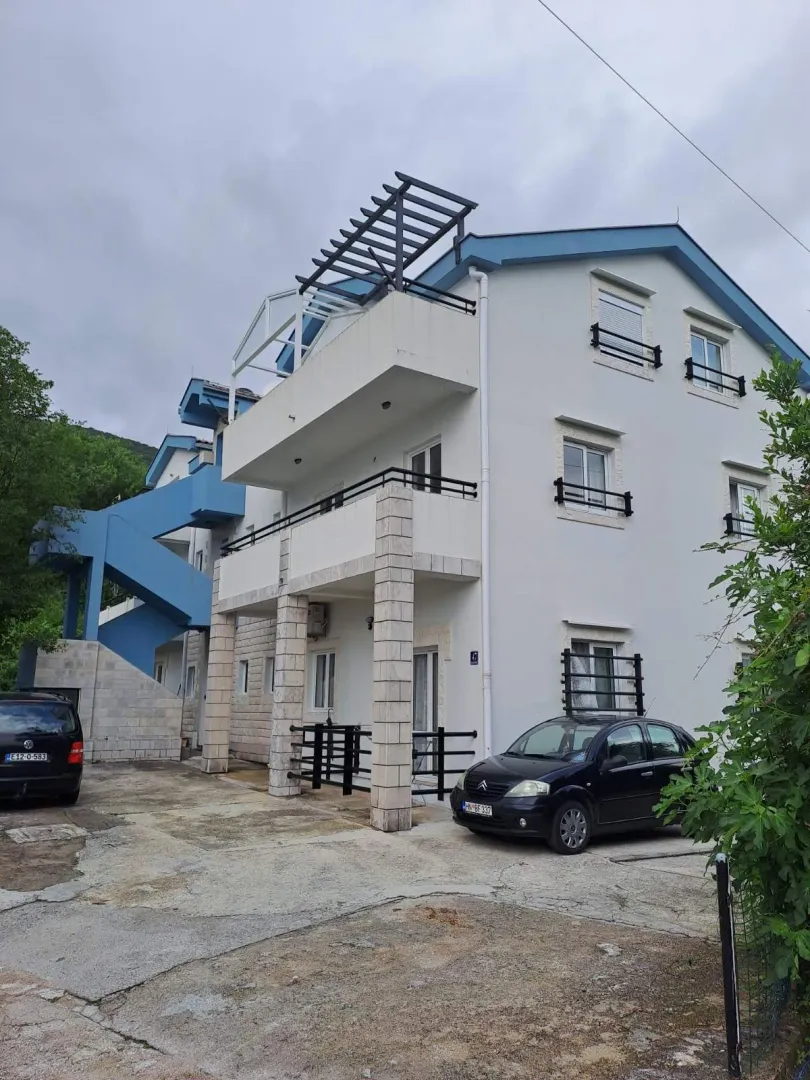 Eksterijer višestambene zgrade sa terasama i dvorištem.