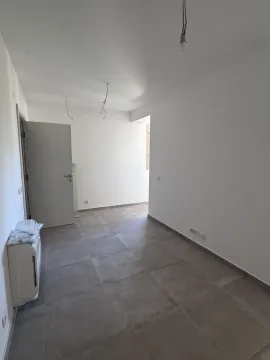 Prazna, novoizgrađena soba sa sivim podnim pločicama i bijelim zidovima. - image 16