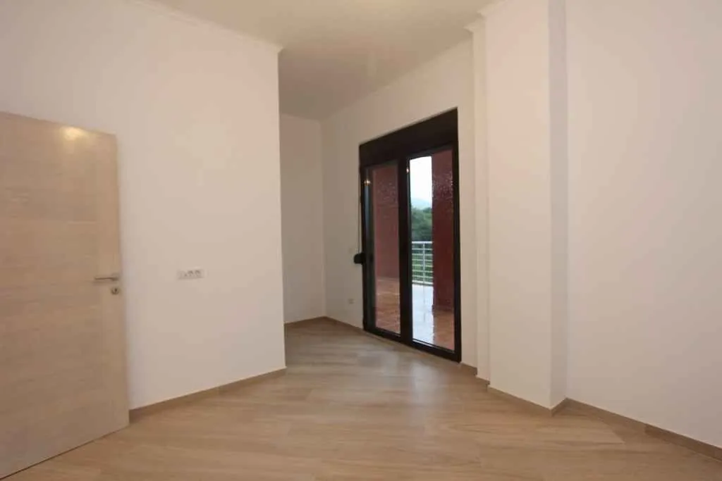 Prazna i svijetla prostorija sa izlazom na balkon.