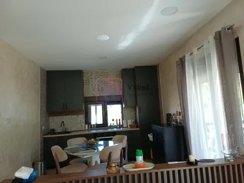 Kitchen with dark cabinets and a dining table. - image 13