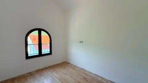 Prazna prostorija sa drvenim podom i prozorom neobičnog oblika. - image 4