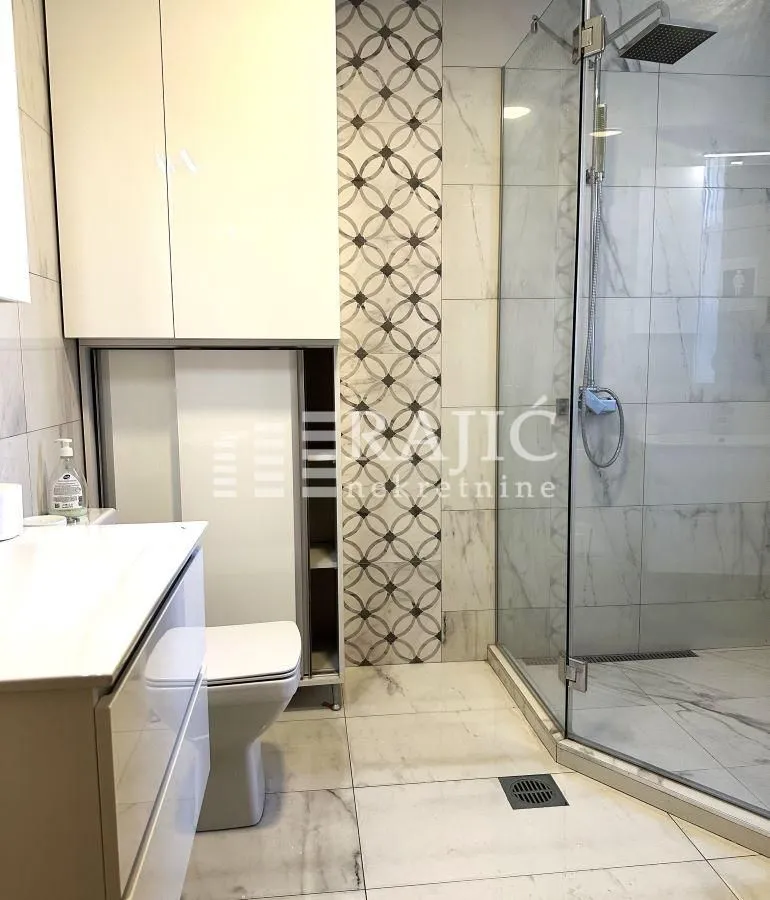 Modernly equipped bathroom with a walk-in shower and washbasin.