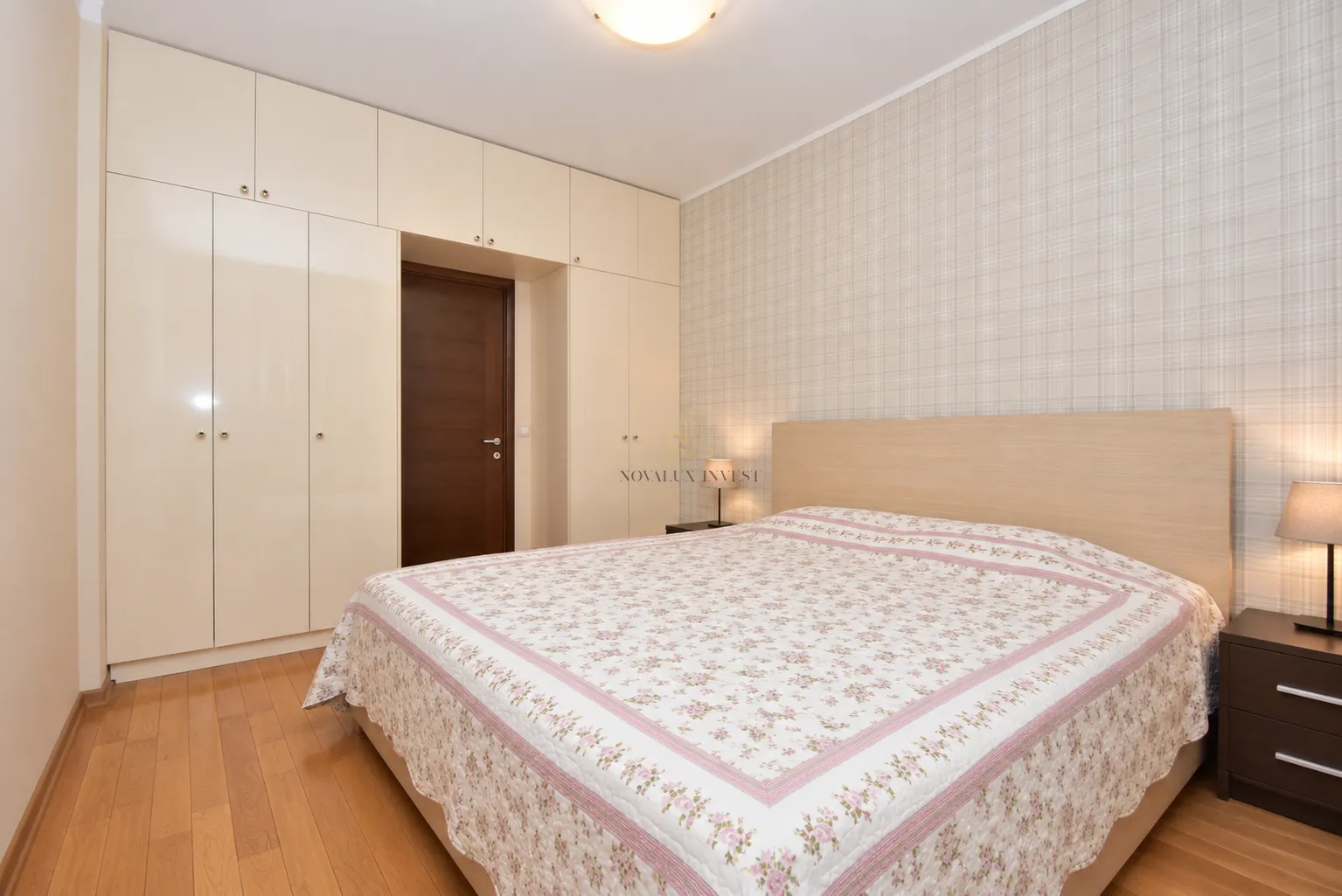 Furnished bedroom with a double bed, built-in wardrobe, and nightstands.