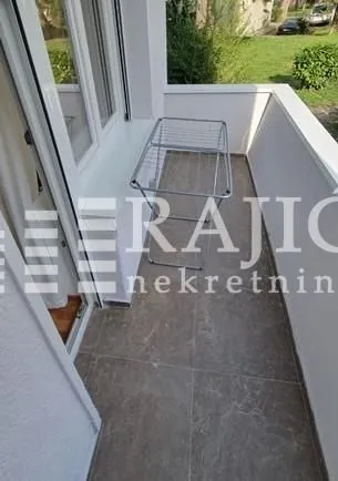 View of a spacious balcony with a clothes drying rack.