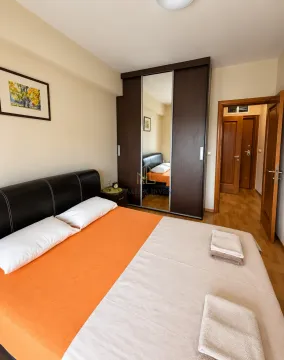 Furnished bedroom with a double bed, wardrobe, and a door leading to the hallway. - image 7