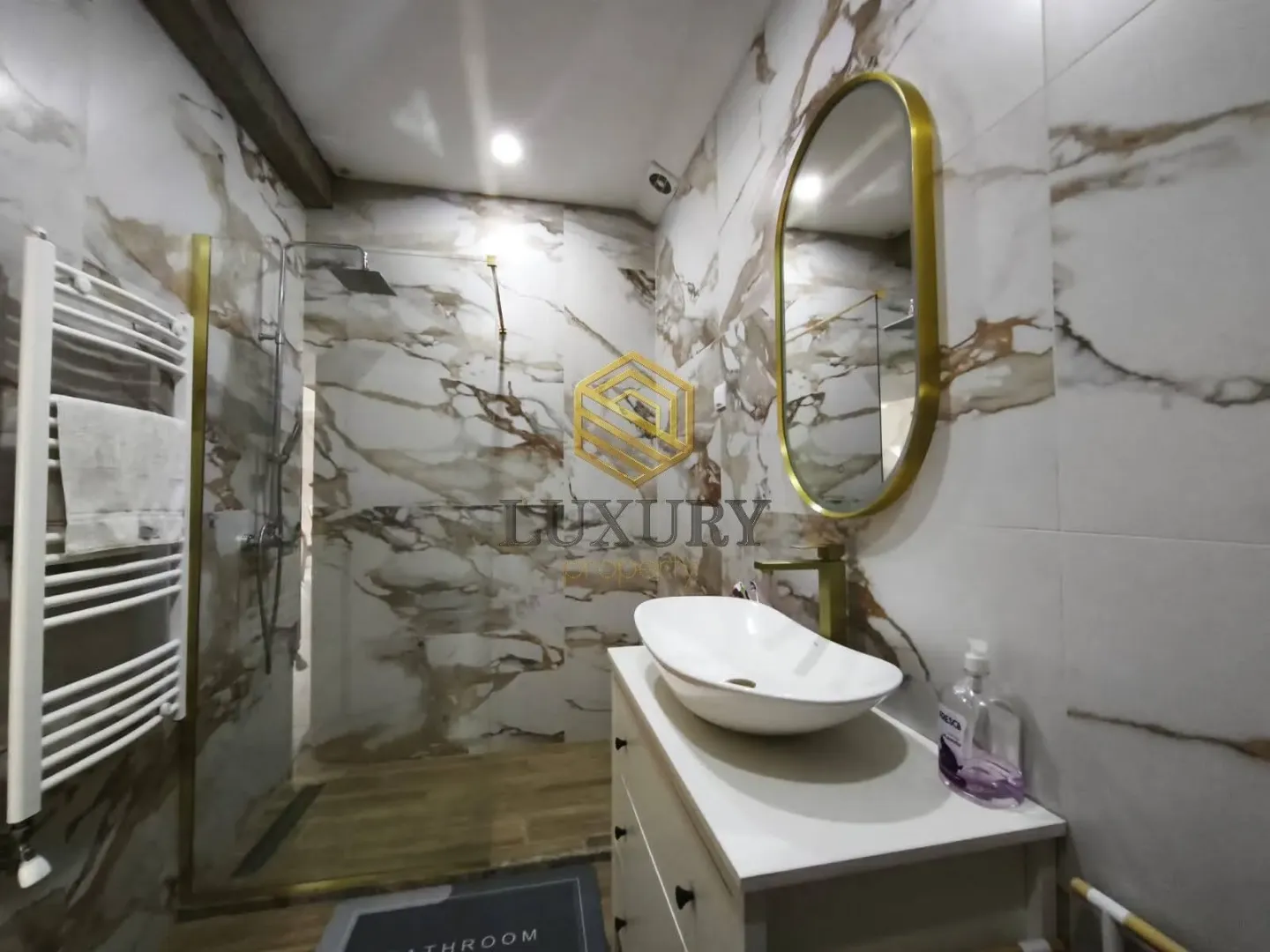 Modern bathroom with marble tiles and a walk-in shower.