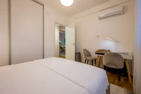 Namještena spavaća soba sa bračnim krevetom, radnim stolom i klima uređajem. - image 12