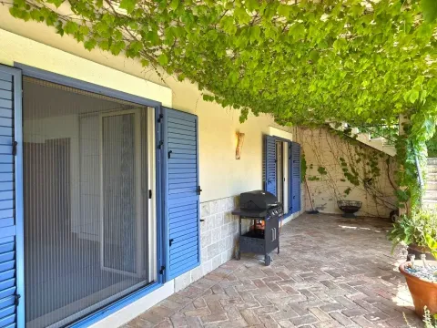 Popločano dvorište sa roštiljem i nadstrešnicom od zelenog rastinja. - image 8