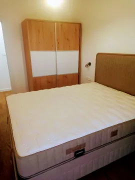Namještena spavaća soba sa bračnim krevetom i drvenim garderoberom. - image 15