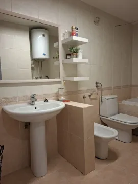 Bathroom equipped with a washbasin, toilet, bidet, and a wall-mounted water heater. - image 11
