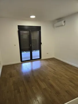 Empty room with parquet flooring and access to a balcony. - image 6