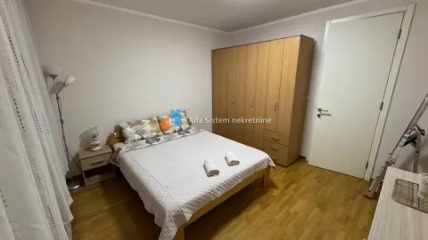 Nameštena spavaća soba sa bračnim krevetom, drvenim ormanom i parketom na podu. - image 15