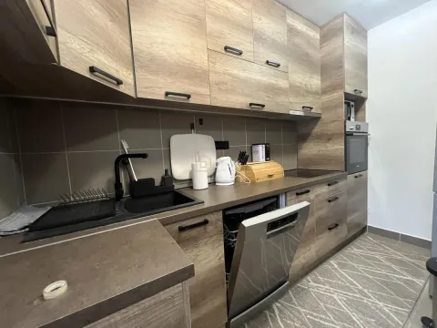 Modern kitchen with wooden cabinetry and built-in home appliances. - image 6