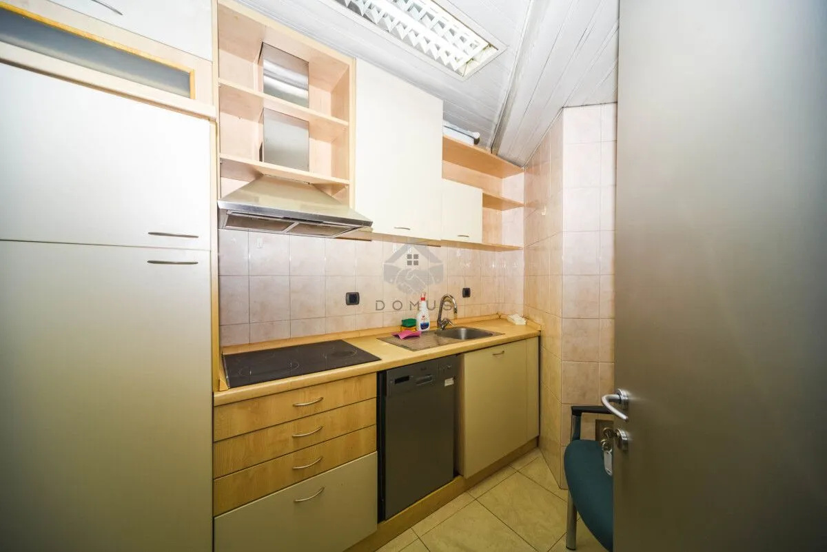 Smaller kitchen with wooden cabinets, sink, and built-in cooktop.