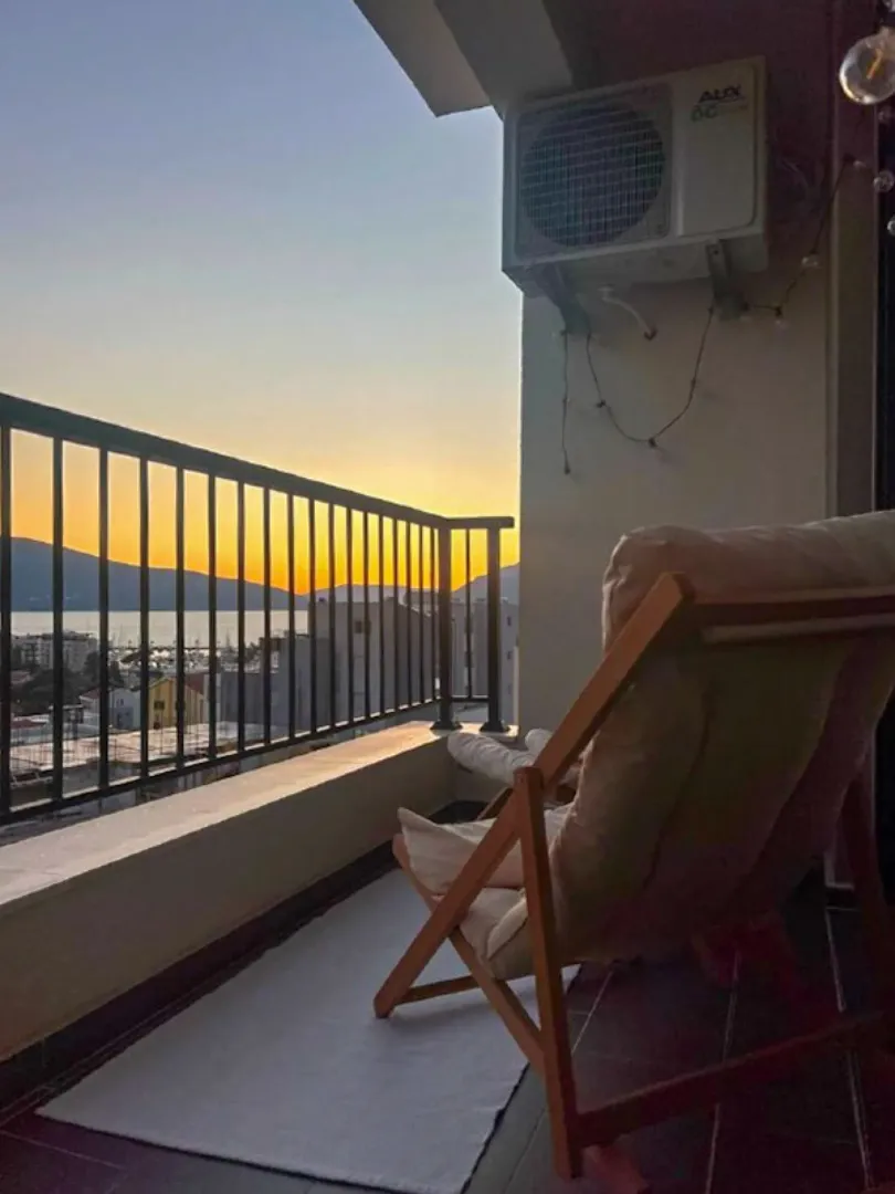 Namješten balkon sa stolicom za opuštanje i pogledom na zalazak sunca.