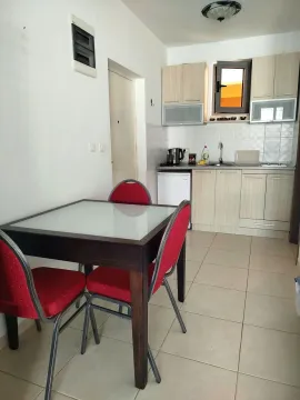 Small kitchen with a dining table and red chairs. - image 3