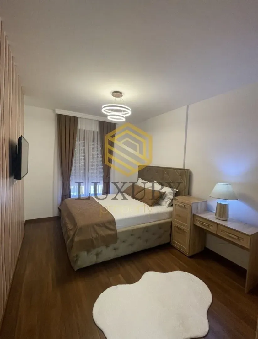 Moderna spavaća soba sa bračnim krevetom, plakarom i radnim stolom.