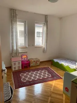 Children's bedroom with a bed, windows, and a rug on the floor. - image 7