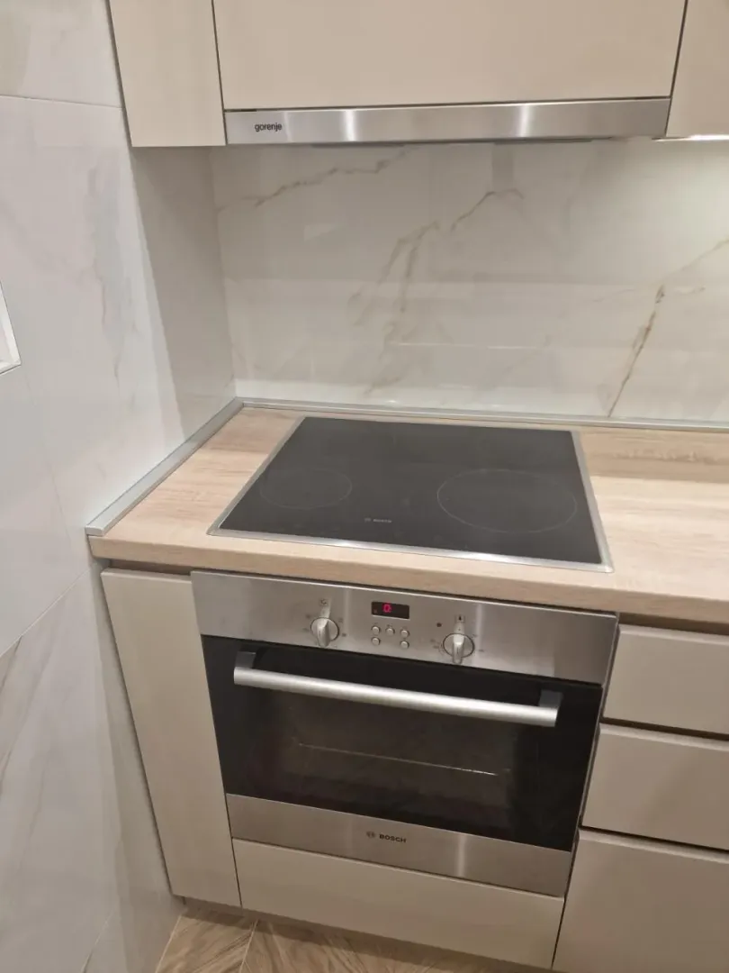 Detalj kuhinje sa ugrađenom rernom i ravnom pločom.