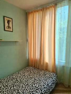 Manja spavaća soba sa krevetom i prozorom prekrivenim zavesama. - image 7