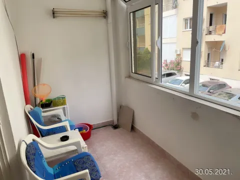 Enclosed balcony with plastic chairs and a table. - image 12