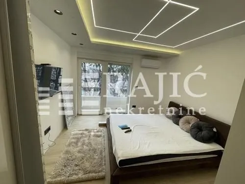 Modern bedroom with a double bed, TV, and access to the terrace.
