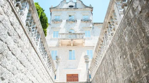 Kamena fasada istorijske zgrade sa raskošnim spoljašnjim stepeništem. - image 9