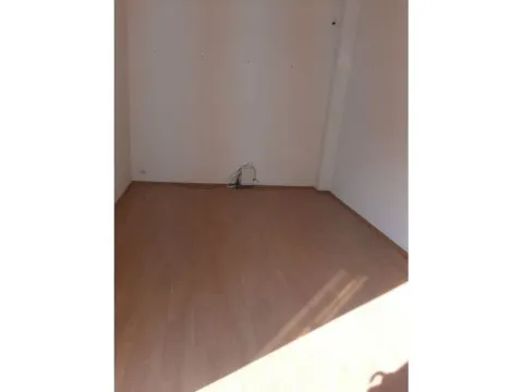 An empty room with laminate flooring and white walls. - image 6