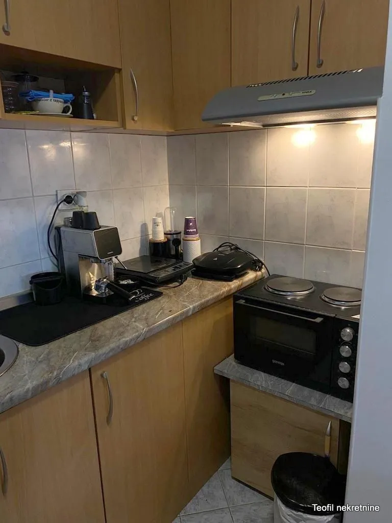 Small kitchen with wooden cabinets, a mini oven, and a countertop.