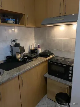 Small kitchen with wooden cabinets, a mini oven, and a countertop. - image 4