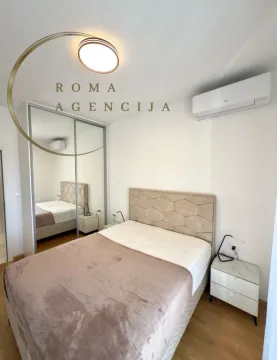 Bright bedroom with a double bed, mirrored wardrobe, and air conditioning. - image 5