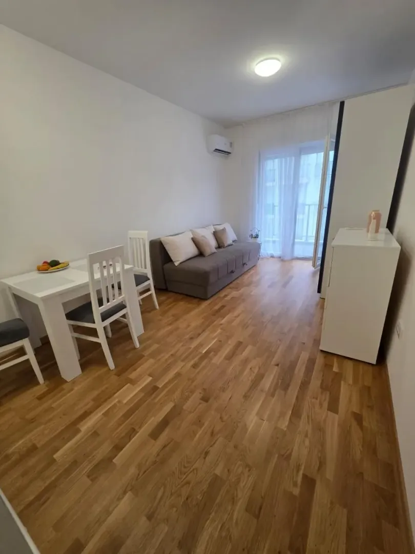 Dnevna soba sa garniturom za sjedenje i trpezarijskim stolom.