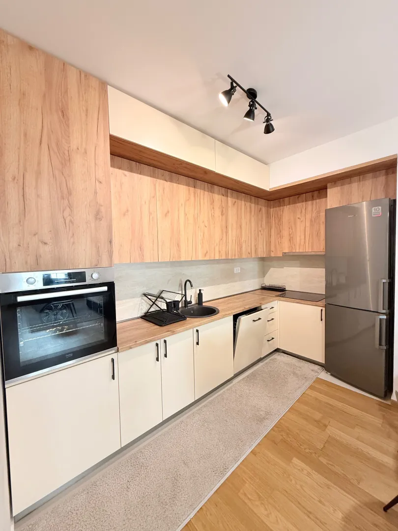 Modern kitchen with wooden elements and built-in appliances.