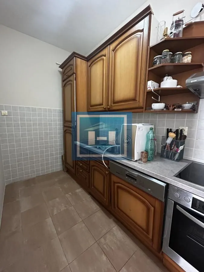 Kuhinja sa drvenim elementima i keramičkim pločicama na zidu.