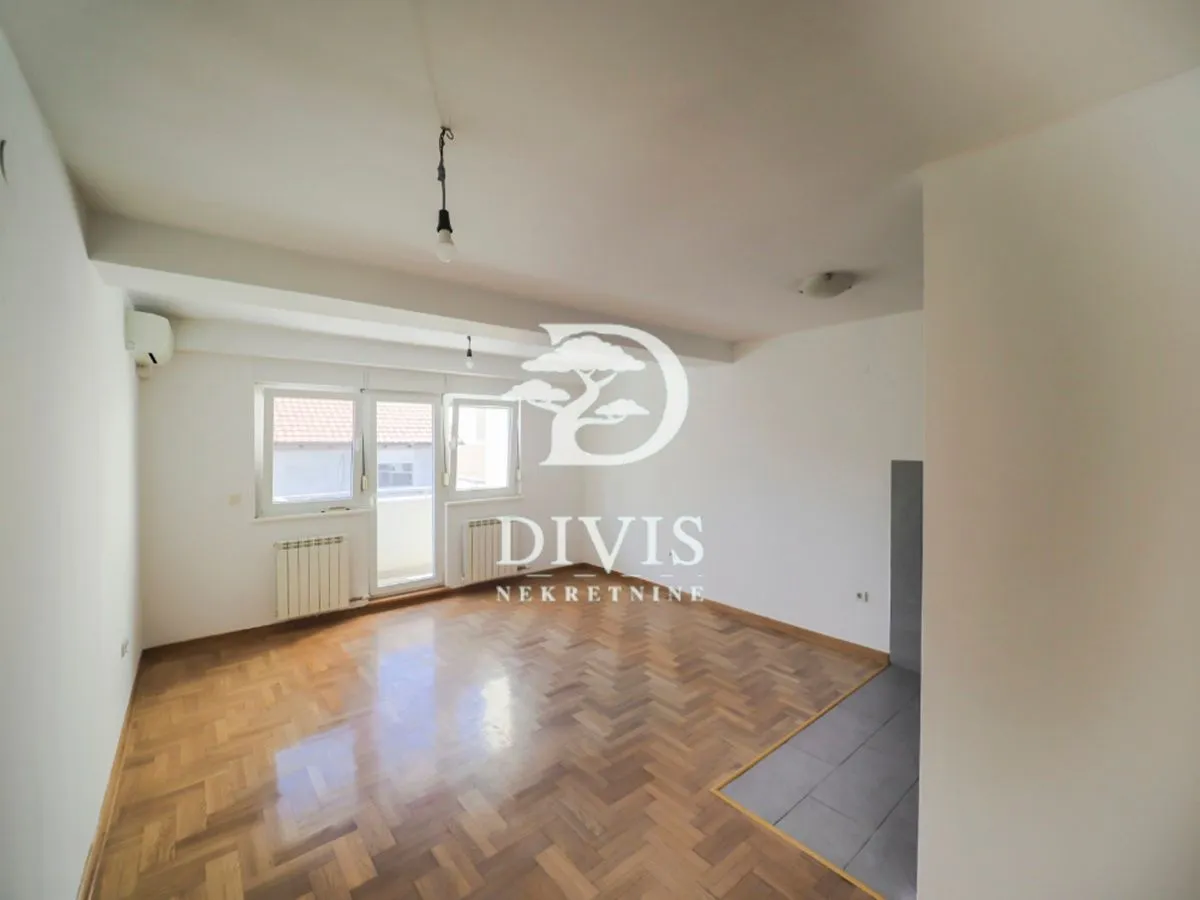 Empty room with parquet flooring and access to a terrace.