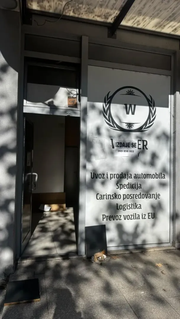 Entrance to a commercial space with a sign on the storefront.