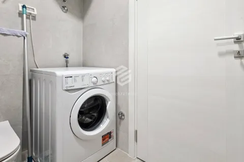 Bathroom with a washing machine and white door. - image 3