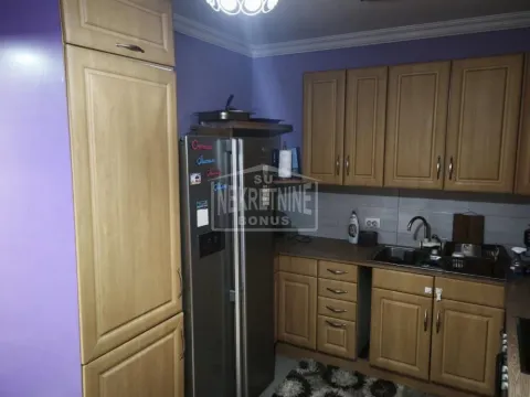 Kuhinja opremljena drvenim elementima i frižiderom. - image 14