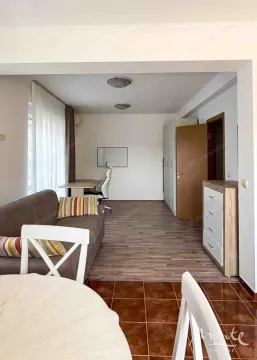 Pogled na dnevni boravak sa trosjedom, radnim stolom i trpezarijskim stolom u prvom planu. - image 6